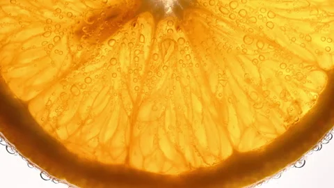 Macro orange slice edge with bubbles in sparkling drink on white 库存影片 331259653