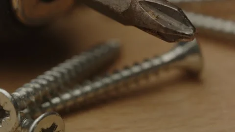 Macro Pan of screws and drill bit on a wooden surface Stock Footage 261129204