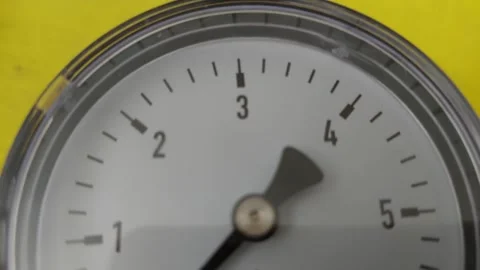 Macro pan shot of a round mechanical pressure gauge dial indicator with a black Stock Footage 336487750