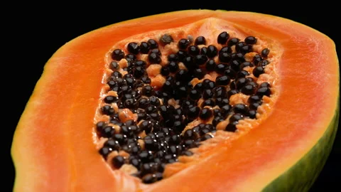 Macro of papaya cross-section rotating. Isolated on black background. Vídeo Stock 169843427