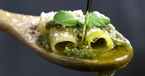 Macro of parmesan cheese being grated on pasta with green pesto Genovese sauce Stock Footage 268880562