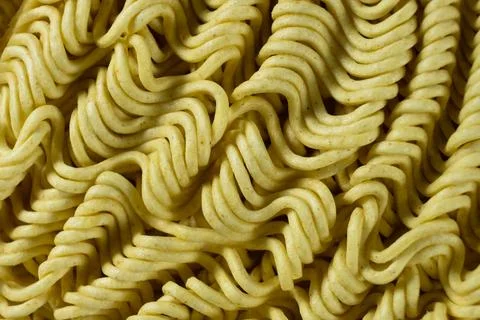 Macro pattern of dry yellow wavy instant noodles Stock Photos
