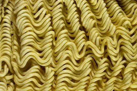 Macro pattern of dry yellow wavy instant noodles Stock Photos