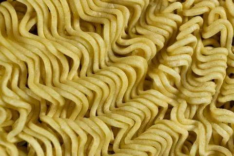 Macro pattern of dry yellow wavy instant noodles Stock Photos