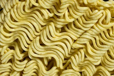 Macro pattern of dry yellow wavy instant noodles Stock Photos