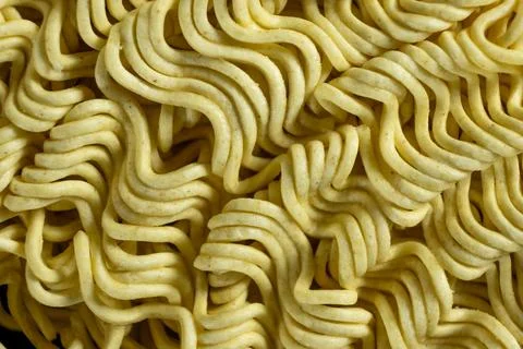 Macro pattern of dry yellow wavy instant noodles Stock Photos