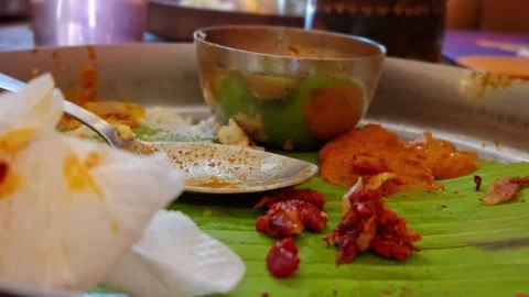 Macro perspective of a messy platter after a meal showing leftover spicy chutney Stock Footage 342992698