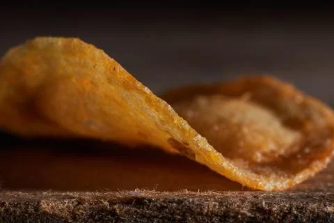 Macro photo of chips on a wooden table, a slice of fried potatoes, beer snacks Stock Photos