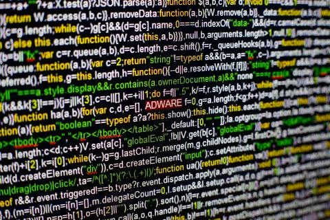 Macro photo of computer screen with program source code and highlighted ADWARE Foto stock