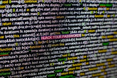 Macro photo of computer screen with program source code and highlighted HIJACK 스톡 사진