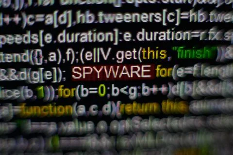 Macro photo of computer screen with program source code and highlighted SPYWARE Foto stock