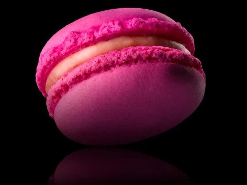 Macro photo of french pink rose macaroon with reflection isolated on black Stock Photos