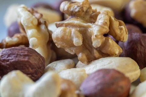 Macro photo of a walnut kernel among assorted mixed nuts Stock Photos