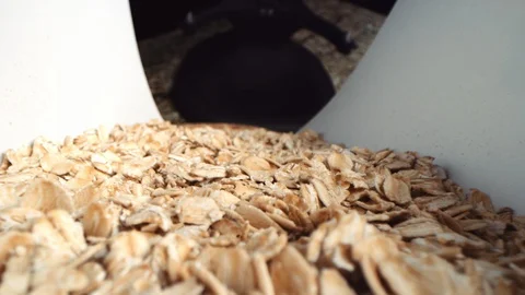 Macro point of view of oats sliding into large wooden bowl in slow motion Video stock 129291282