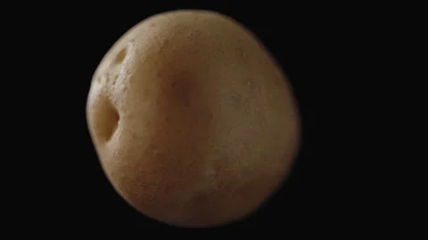 Macro, potato tuber rotating on its axis on black background Stock Footage 268619768