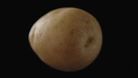 Macro, potato tuber in a swivel motion on a black background Stock Footage 247143771