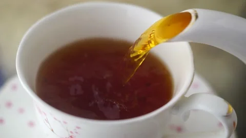 Macro Pouring Fresh Black Ceylon Tea Into White Porcelain Cup, Lemon 4K Stock Footage 144679131