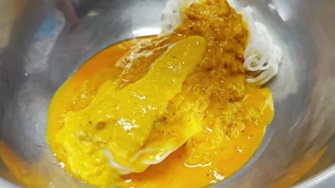 Macro pouring yellow curry sauce over Thai rice noodles. Stock Footage 342515948