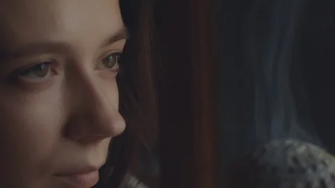 Macro profile of female face looking at steaming censer indoors on dark Stock Footage 127579542
