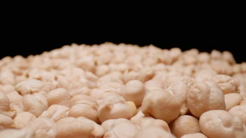 MACRO: Raw dried chickpeas grains. Healthy food. Black background. Dolly motion. Stock Footage 144417512