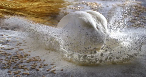 Macro of raw loaf of dough falling with wheat grain seeds and flour dust splash Stock Footage 268804548