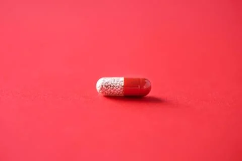 Macro of red capsules on red background. Copy space. Bunch of drugs, cold flu Stock Photos