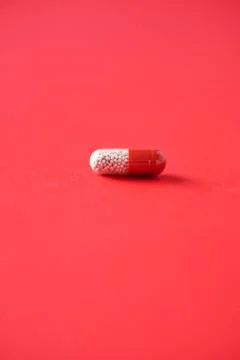 Macro of red capsules on red background. Copy space. Bunch of drugs, cold flu Stock Photos