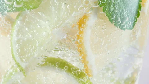 Macro refreshing soda tonic fizzy sparkling water, lime in glass, ice cubes Stock Footage 155088076