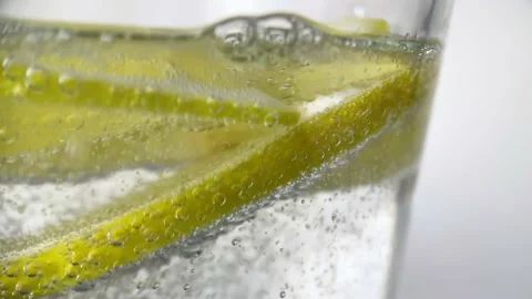 Macro refreshing soda tonic fizzy sparkling water, lime in glass, ice cubes Stock Footage 234453406
