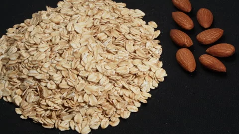 Macro Rotating Rolled Oats and Raw Almonds on Black. Stock Footage 333045859