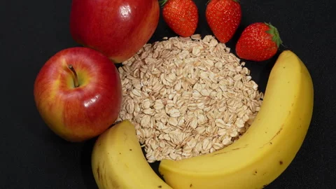 Macro Rotating Rolled Oats with Mixed Fresh Fruits on Black. 스톡 동영상 333046412