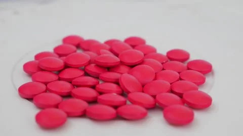 Macro rotating shot of pink tablets placed over a table Vídeo Stock 147700167