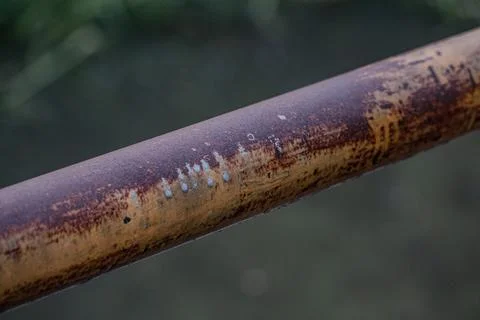 Macro of rusty iron railing at twilight on weathered metal pipe Фото
