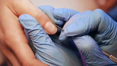 Macro salon close-up of a technician refining the cuticle rim with a fine bit Stockbeeldmateriaal 333655331