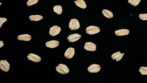 Macro Scattered Rolled Oat Grains Rotating on Black Background. Stock Footage 333047141
