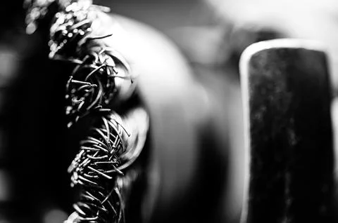 Macro selective focus on the bristle ends of a wire brush wheel on a grinder. Stock Photos
