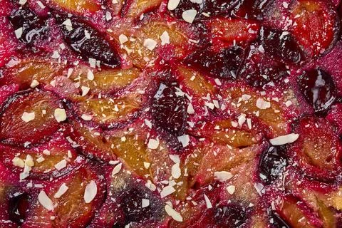 Macro selective focus food background tart or pie with plums and almond petals Stock Photos