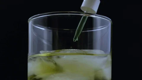 Macro seven drops green liquid added to beverage Stock Footage 70687206