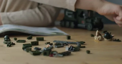 Macro shallow front view of child hands constructing car at wooden table natural Stock Footage 146570014