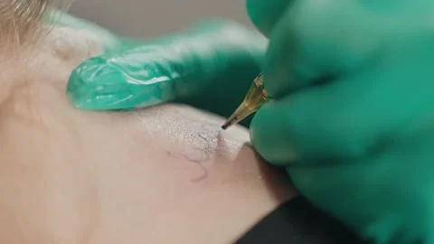 Macro shoot on client skin in process of stuffing tattoo letters with machine. Stock Footage 219549285