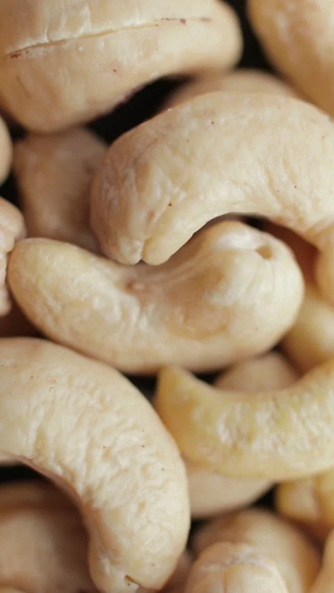 Macro shooting of a cashew nuts heap. Rotating on the turntable. Vertical video. Video stock 274209022