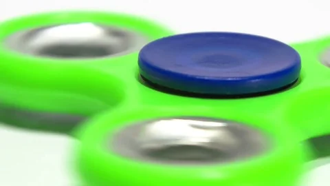 Macro Shooting Green spinner rotates on a white background. Stock-Footage 77735383