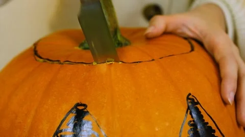 Macro shooting. The knife goes into the top of the gourd. Halloween. Stock Footage 219255995
