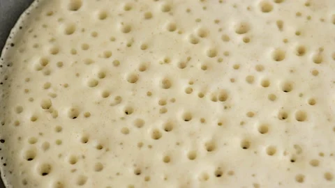 Macro shooting, motion camera. Big round pancake on induction frying pan Stock Footage 148562536