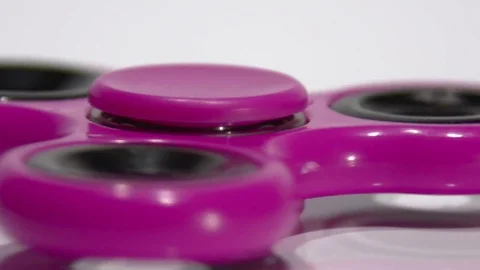 Macro Shooting Purple spinner rotates on a white background. Video stock 77735246