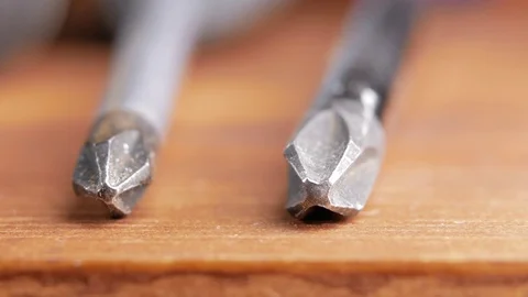 Macro shooting. Several screwdrivers lie on a wooden table: Phillips and flat Stock Footage 73392574