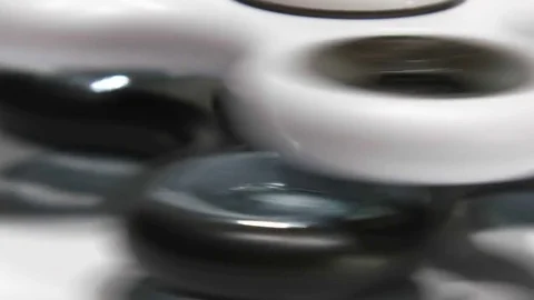 Macro Shooting spinner rotates on a white background. Stock Footage 77735402