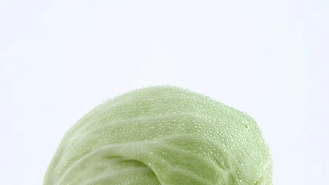 Macro shooting of upper part of one whole mini white cabbage with water drops. 스톡 동영상 93843145