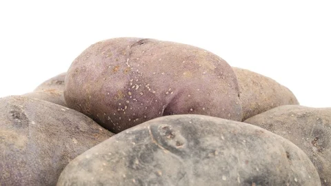 Macro shooting of upper part of violet potatoes pile. Slowly rotating  Stock Footage 96345838