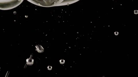 Macro shot of air bubbles in water rising up on light black background. Slow Stock Footage 166475220
